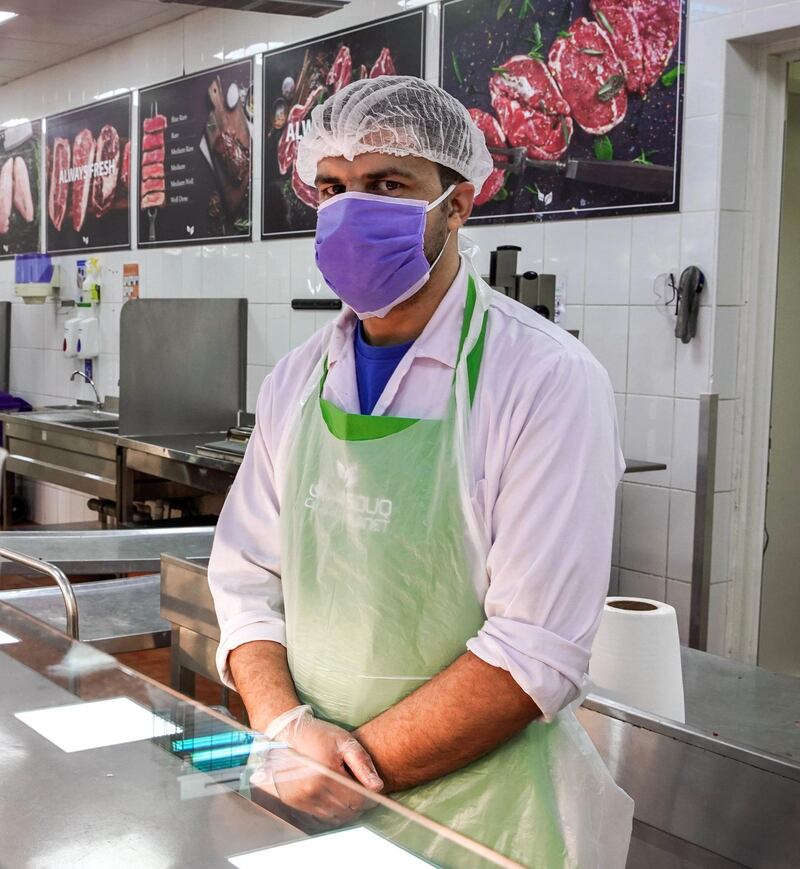Omar Edehmen, from Morrocco, is the head butcher at Souq Planet in Abu Dhabi. He says: "The first thing I do before I go to my work area is to thoroughly wash my hands before putting on my gloves. When I remove my gloves, I use hand sanitiser. If I know I touched something out of the work area, I wash my hands again before putting a new pair of gloves. A face mask is also always used when in the work area." Victor Besa / The National