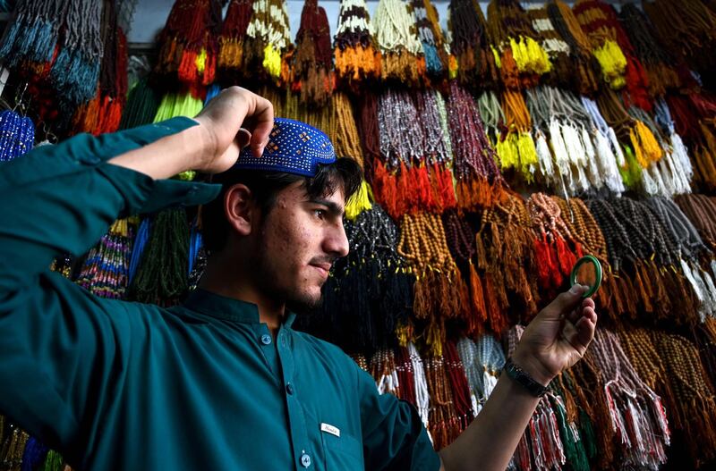 A Pakistani Muslim poses as he tries on a traditional prayer cap at a shop in Rawalpindi ahead of the start of Ramadan.
AFP