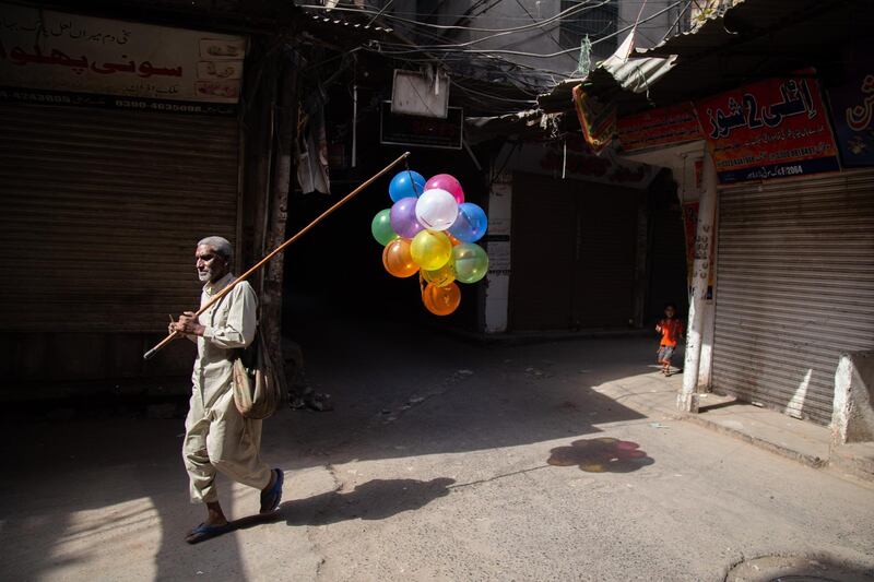 A balloon seller walks through a closed market on May 1, 2021 in Lahore, Pakistan, amid a weekend lockdown put in place to curb the spread of the coronavirus. Getty Images