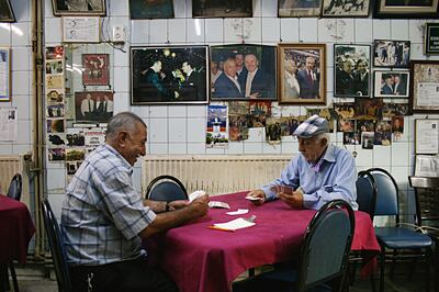Men play cards at Yashar Hoca’s Place, in Recep Tayyip Erdogan's old Istanbul neighborhood, Kasimpasha, surrounded by photos of Mr Erdogan and other Justice and Development Party (AKP) politicians. Piotr Zalewski for The National 