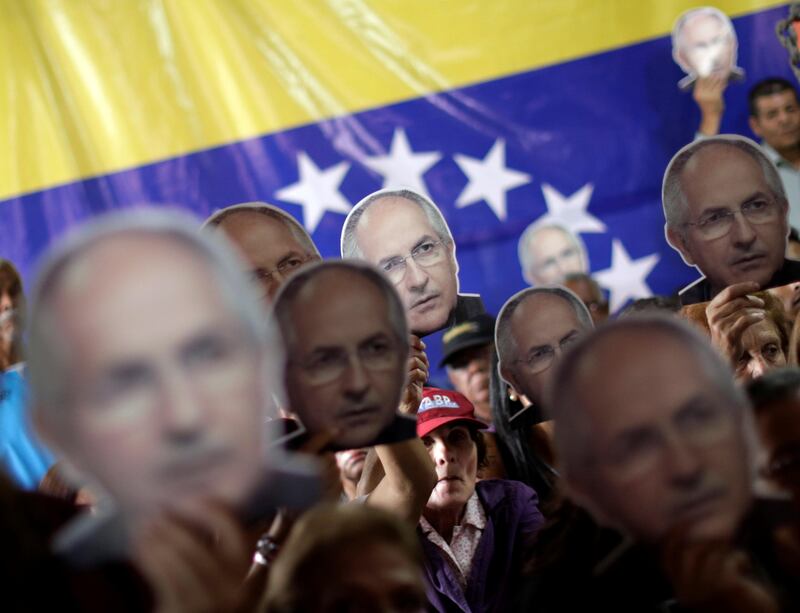 People hold portraits of opposition leader Antonio Ledezma during a news conference at the Venezuelan coalition of opposition parties (MUD) headquarters in Caracas, Venezuela August 1, 2017.   REUTERS/Ueslei Marcelino