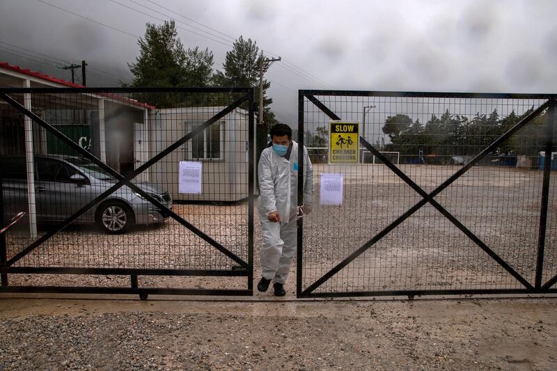 A man wearing a protective suit and a face mask exits the Malakasa migrant camp after authorities found a coronavirus case and placed the camp under quarantine, following the outbreak of coronavirus disease (COVID-19), in Malakasa, Greece, April 5, 2020. REUTERS/Alkis Konstantinidis