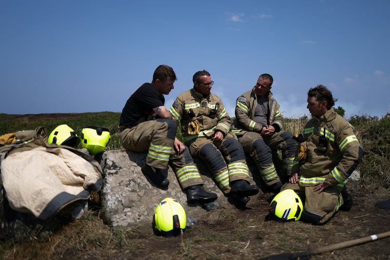 Firefighters rest as they attend a gorse bush fire, near Zennor, Cornwall. Reuters