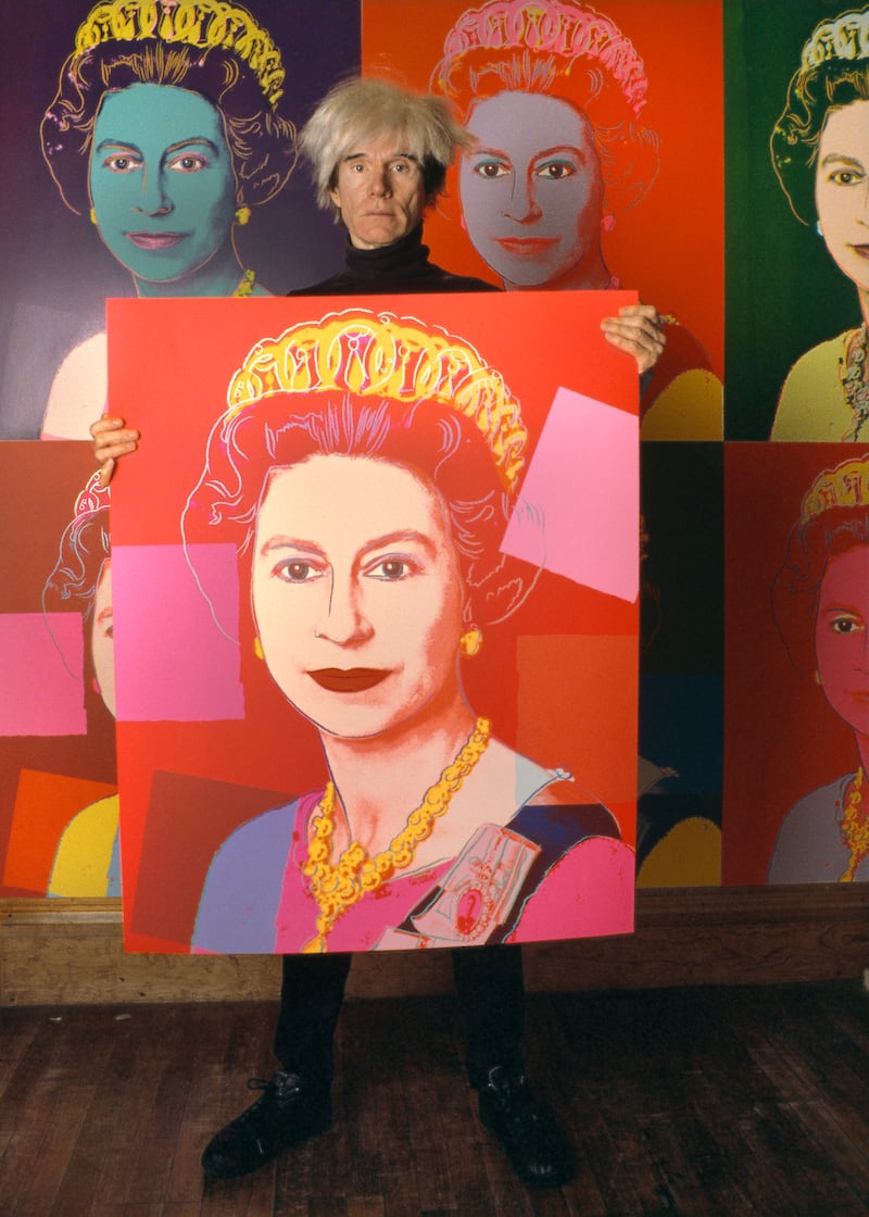 Ai-Da may be the first robot to create a portrait of the monarch, but she certainly isn't the first artist. Here American Pop artist Andy Warhol holds a silkscreen print of Queen Elizabeth in his studio, the Factory, in New York, 1985. Getty Images