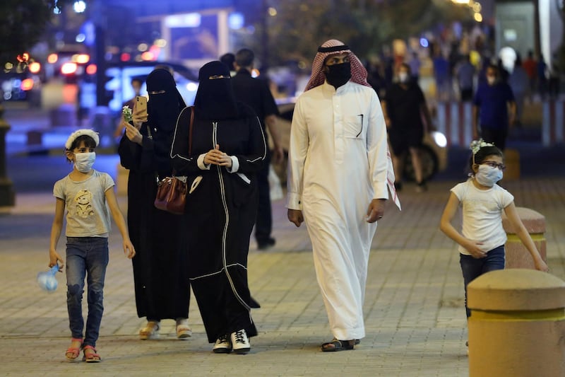 FILE PHOTO: A Saudi family wearing protective face masks walk on Tahlia Street as nightlife kicks off, after the government loosened lockdown restrictions following the outbreak of the coronavirus disease (COVID-19), in Riyadh, Saudi Arabia June 21, 2020. Picture taken June 21, 2020. REUTERS/Ahmed Yosri/File Photo
