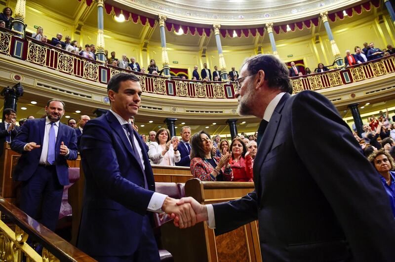 Spain's new Prime Minister and Socialist party (PSOE) leader Pedro Sanchez shakes hands with ousted Prime Minister Mariano Rajoy. Pierre-Philippe Marcou / Reuters