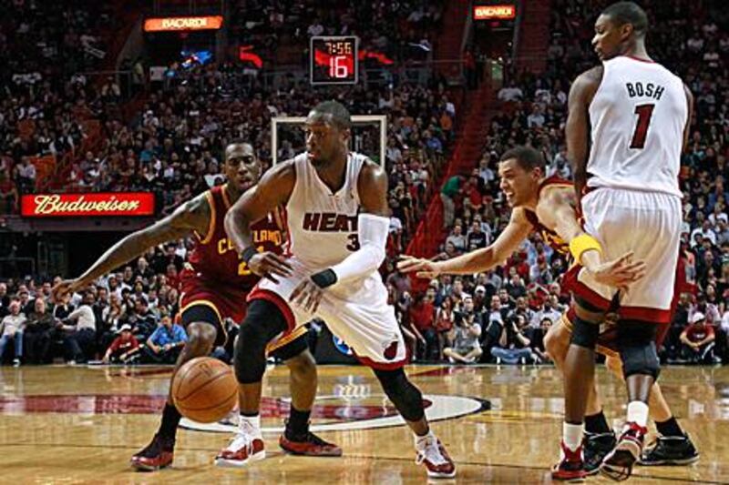 Miami Heat's Dwyane Wade, centrem drives past JJ Hickson of the Cleveland Cavaliers during the first quarter.