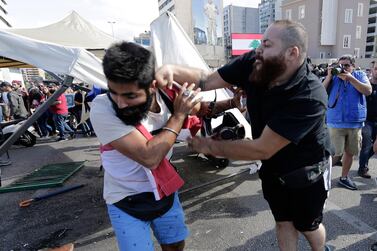 A Hezbollah supporter, right, fights with an anti-government protester during clashes at ongoing protests against the Lebanese government in Beirut. AP 