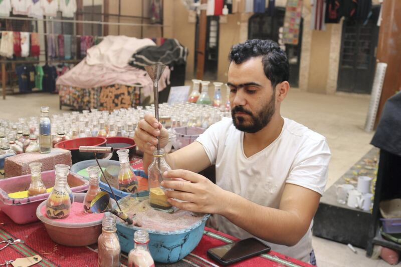 Nadim Tantawi crafts a decorative sand bottle at his stand in the empty visitors centre at Jerash, Jordan on October 21, 2020. Taylor Luck for The National