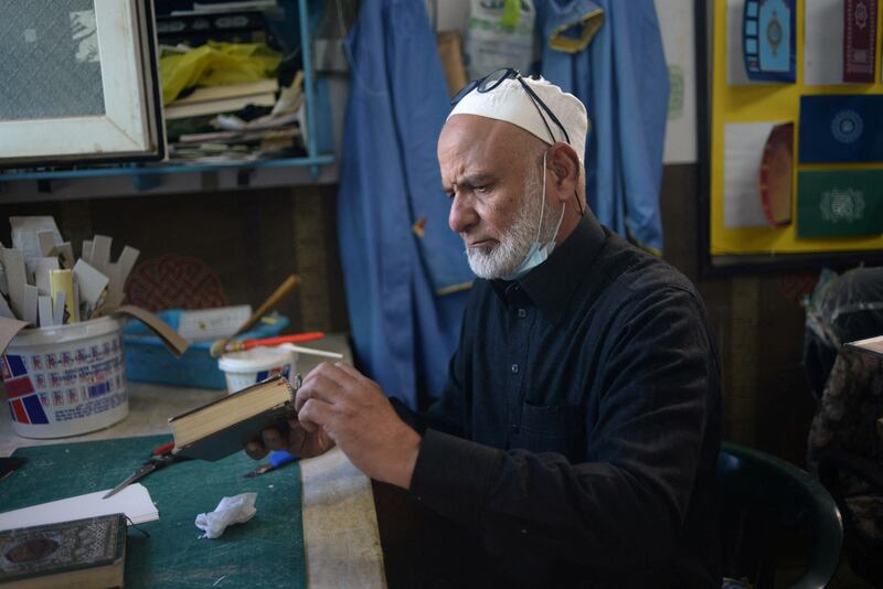 A Libyan volunteer repairs a Quran in Tripoli. Reuters