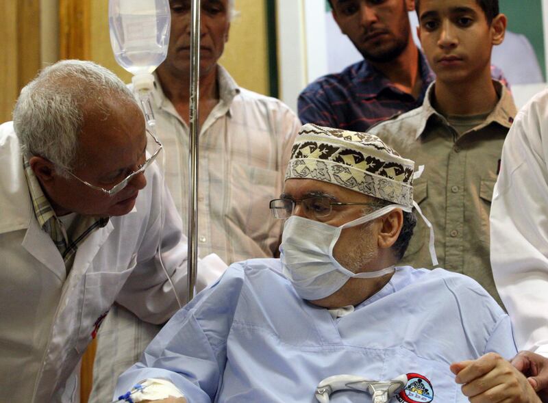 (FILES) In this file photo taken on September 09, 2009 freed Lockerbie bomber Abdelbaset Ali Mohmet al-Megrahi speaks to a doctor as he wears a medical facemask in a wheelchair during a meeting with an African delegation at a hospital in Tripoli. Five judges at Scotland's highest court of criminal appeal on January 15, 2021 issue their ruling in a posthumous appeal by the family of Lockerbie bomber Abdelbased Ali Mohmet al-Megrahi. / AFP / Mahmud TURKIA
