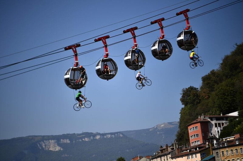 Cyclists hanging under the Grenoble Bastille cable cars during the 17th stage of the 107th edition of the Tour de France cycling race, 170km between Grenoble and Meribel.  AFP