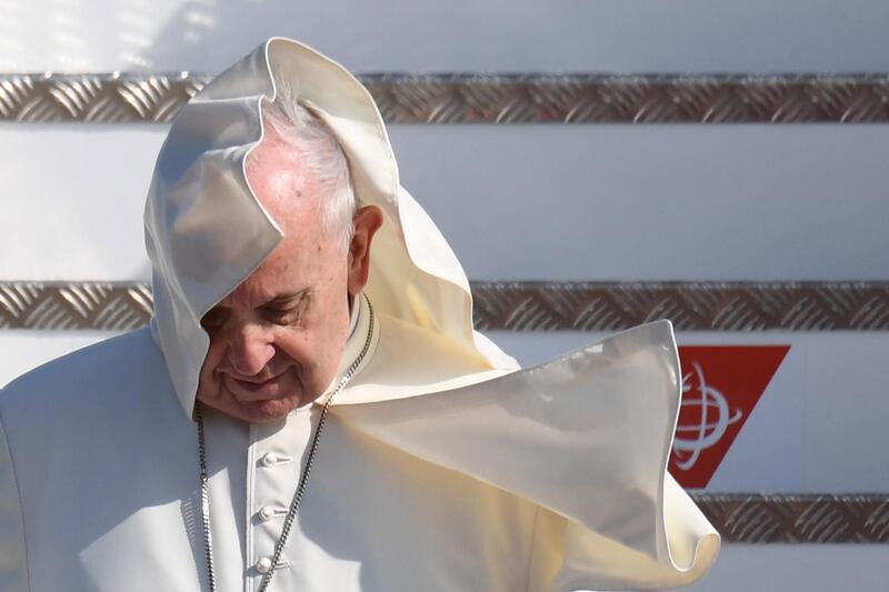 A breeze catches and blows up Pope Francis' collar as he disembarks from the plane. EPA