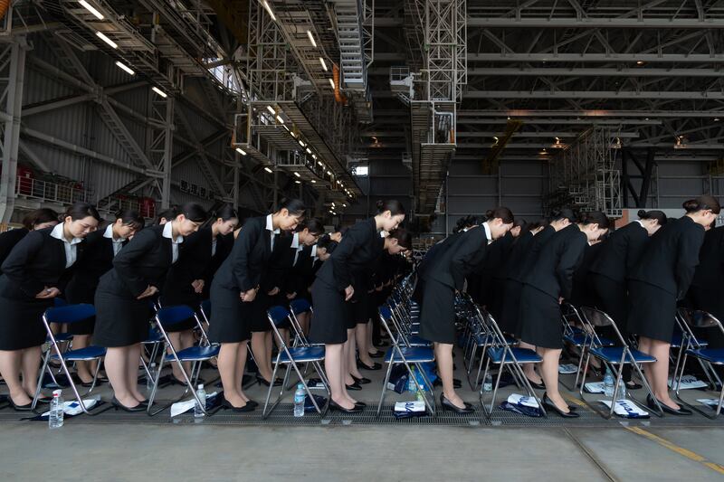 Newly-hired employees bow as they attend the entrance ceremony for ANA Group in an aircraft hangar at Haneda Airport in Tokyo, Japan. Getty Images