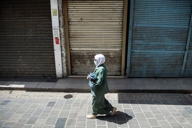 epa08340838 A woman wearing face mask walks in front of closed shops, in Cairo, Egypt, 03 April 2020. Egyptian authorities have imposed a two-week-long curfew, starting on 25 March, during which all public transportation in the city is suspended due to the ongoing pandemic of the Covid-19 disease caused by the SARS-CoV-2 coronavirus. EPA/Mohamed Hossam