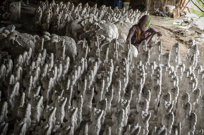 An artisan works on clay idols of Hindu goddess Lakshmi at a workshop in Hyderabad. AFP