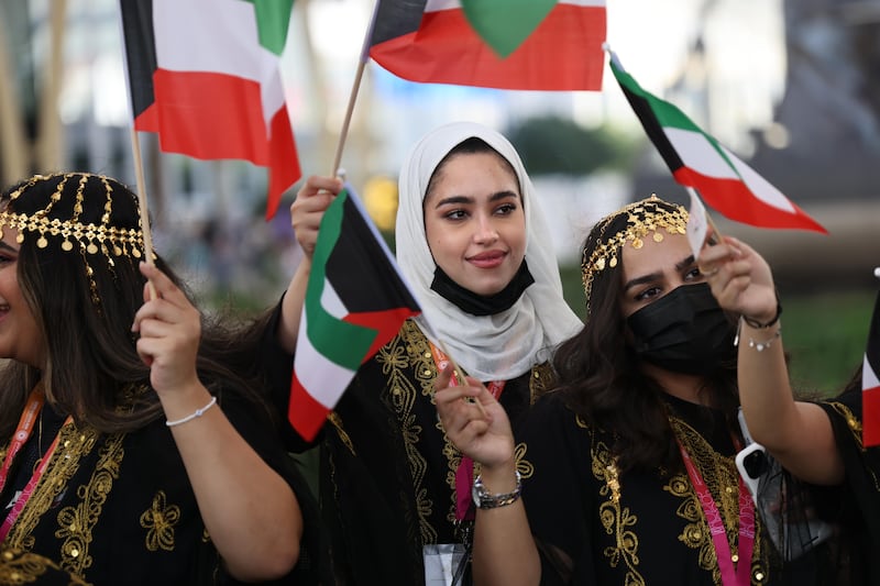 Visitors wave flags on Kuwait National Day. Photo by Palani Mohan / Expo 2020 Dubai