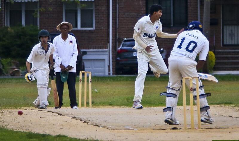 In this May 12, 2014 photo, John Adams High School batsman and bowler Derick Narine, second from right, celebrates after he bowls out Midwood High School batsman Muhammad Awais. Bebeto Matthews / AP