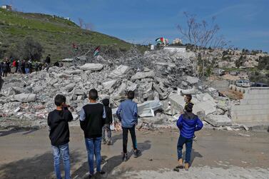 Palestinians stand by the rubble of buildings demolished by Jerusalem municipality workers, reportedly built without an Israeli construction permit, in East Jerusalem, February 22, 2021.  AFP 