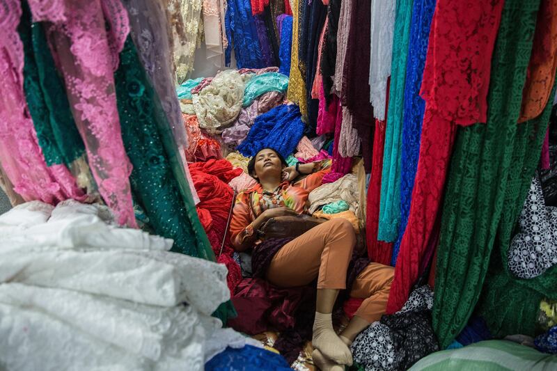 A woman takes a nap in a fabric shop  in Phnom Penh, Cambodia. Bloomberg