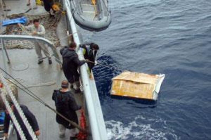 Members of a Brazilian Navy ship pick up a piece of  debris from the Air France Flight 447 in the Atlantic ocean, on June 17 2009.