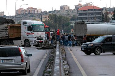 Anti-government protestors block the road on the Sidon-Beirut highway on Friday as protests which began in October rumble on. AFP