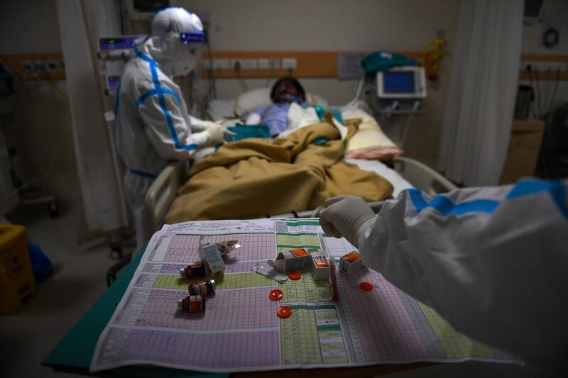 A medical staff assists a Covid-19 coronavirus patient inside an intensive care unit at Max Hospital in New Delhi. AFP
