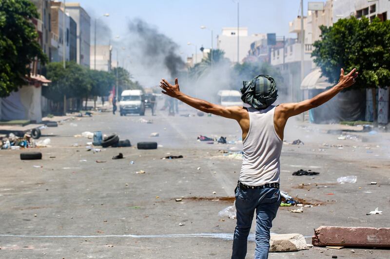 Protesters from Tunisia's Tataouine region throw stones as they clash with security forces.  AFP