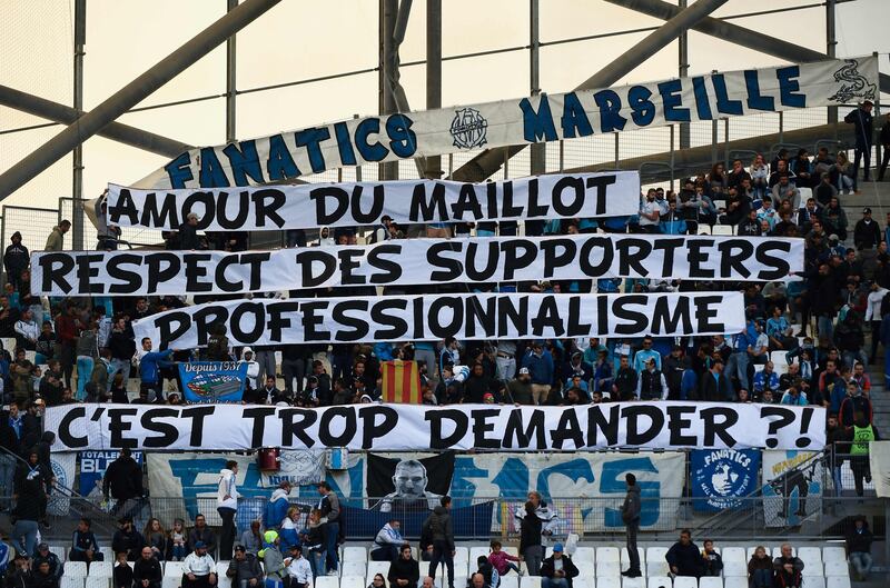 TOPSHOT - Olympique de Marseille (OM) fans hold a banner reading "for the love of the OM jersey, the respect of fans and professionalism, is it too much to ask?", prior to the start of the French L1 football match between Olympique de Marseille (OM) and Caen at the Velodrome stadium in Marseille on November 5, 2017.   
Marseille, in fifth, host Caen at the Velodrome in an atmosphere made tense after Patrice Evra was suspended by the club for aiming a karate kick at the head of one of his team's own supporters. / AFP PHOTO / BORIS HORVAT