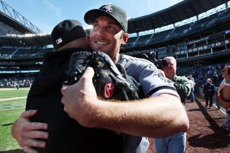 Chicago White Sox starting pitcher Phil Humber, front right, is embraced after pitching a perfect baseball game against the Seattle Mariners, Saturday, April 21, 2012, in Seattle. The White Sox won 4-0. (AP Photo/Elaine Thompson)