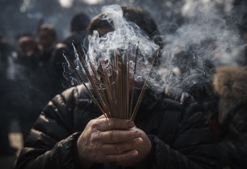 A woman prays for good fortune on the first day of the Lunar New Year in Beijing, China. Getty Images