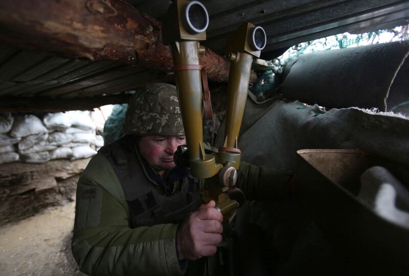 An Ukrainian Military Forces serviceman watches through a spyglass on a trench on the frontline with Russia-backed separatists close to Lugansk village in the Donetsk region last week. AFP