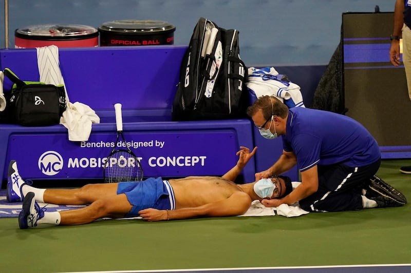 A trainer works on the neck of world No 1 Novak Djokovic during his victory over Ricardas Berankis in the second round of the Western and Southern Open tennis tournament on Monday, August 24. AP