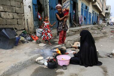 A displaced Yemeni woman prepares food for her children outside their one-room rental house at a street in Sanaa, Yemen. EPA