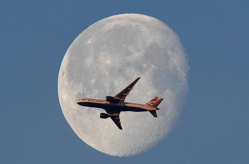 A British Airways jet flies in front of the moon above London. Toby Melville / Reuters