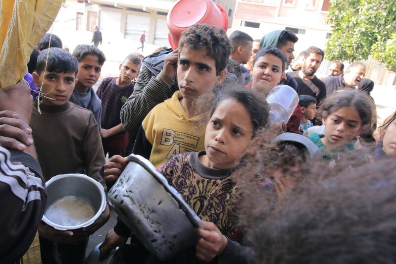 Displaced Palestinian children collect food from volunteers near Nasser Medical Hospital in Khan Younis, southern Gaza. Bloomberg