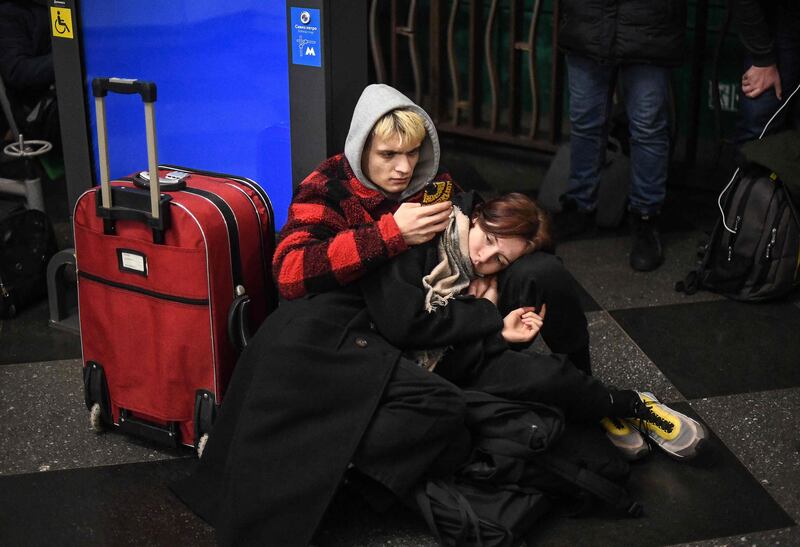 People with many of their belongings packed take shelter in a Metro station in Kiev. AFP