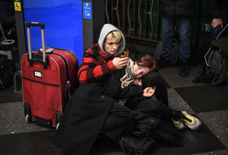 People with many of their belongings packed take shelter in a Metro station in Kiev. AFP
