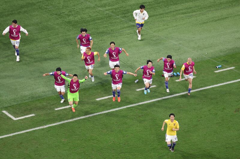 Japan players celebrate reaching the last 16. Getty