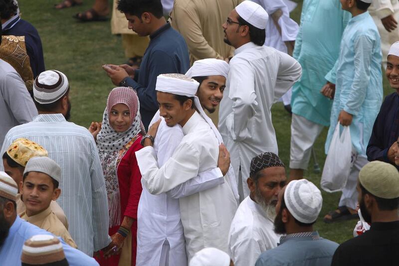 Pakistani share greetings after offering prayers in Karachi. Shakil Adil / AP Photo