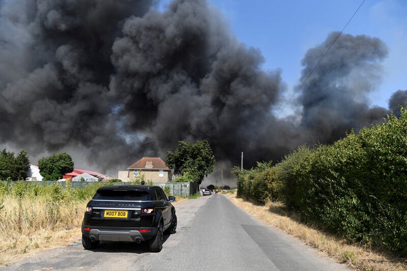 A car drives towards a fire in East London. Reuters