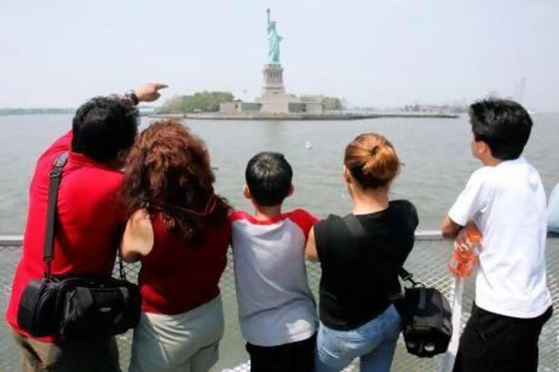 A group of tourists look at the Statue of Liberty in New York. Emiratis can now complete the US visa process in a week at quiet times and three weeks during peak season. AFP PHOTO/DON EMMERT