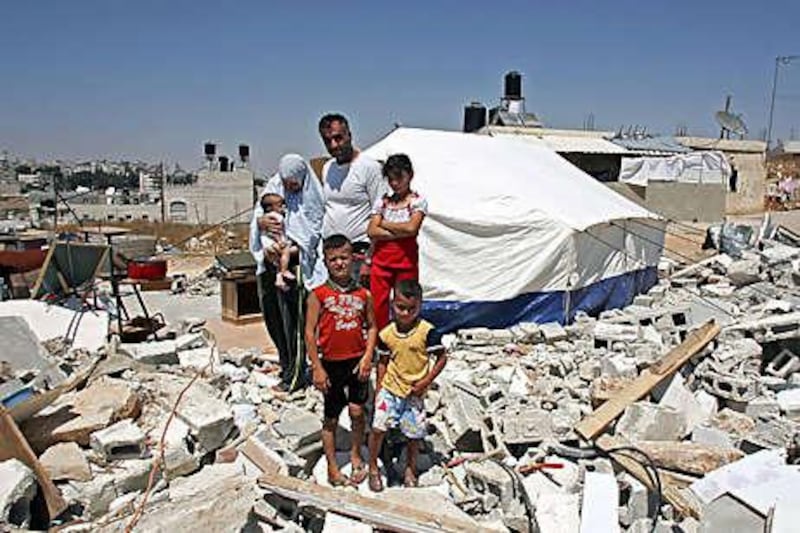 Hafez al Rajabi stands with his wife Dalal and children stand amid the ruins of their home in Beit Hanina in East Jerusalem.