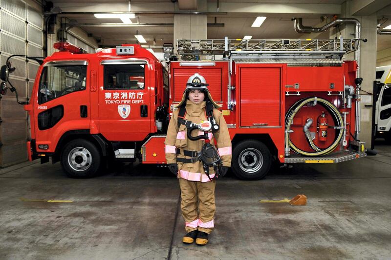 To mark the occasion of International Women's Day on March 8, 2018 AFP presents a series of 45 photos depicting women performing roles or working in professions more traditionally held by men.  More images can be found in www.afpforum.com  Search SLUG  "WOMEN-DAY -PACKAGE". 
This picture taken on February 23, 2018 shows Ran Namise, 24, a firefighter belonging to the command squad, posing in front of a fire engine at Kojimachi Fire Station in Tokyo. 

In the ring, battling flames or lifting off into space, women have entered professions generally considered as men's jobs. For International Women's Day, AFP met with women breaking down the barriers of gender-bias in the work world. / AFP PHOTO / Kazuhiro NOGI