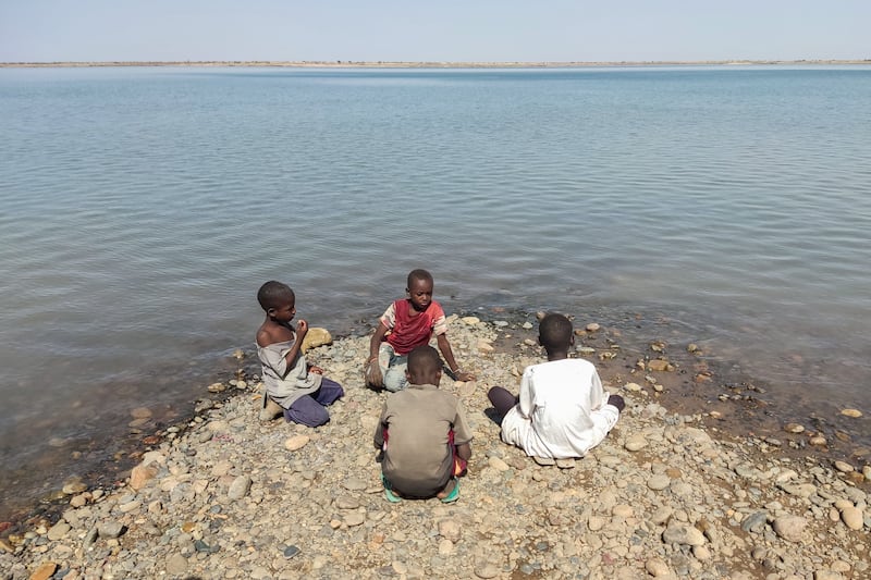 Children sit on the bank of the Seteit river in Gadaref, eastern Sudan. The civil war has pushed 18 million Sudanese into acute food insecurity. AFP