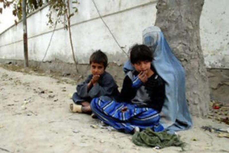 Mawjuda begs on a street in Kabul with Nazar and Parmena, who she said were her children.