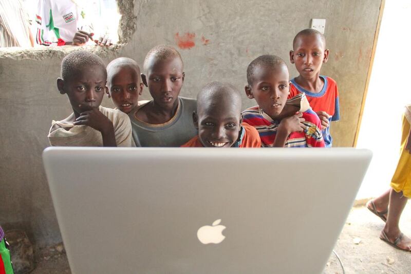 Rural Kenyans get a first look an Apple laptop during a technology outreach effort. David Mbiyu / Demotix