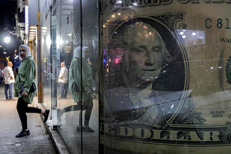 A currency exchange shop displaying a giant US dollar banknote in the Zamalek district of Egypt's capital Cairo. Depleted foreign currency reserves are casting a shadow on Egyptian streets, with the government moving to dim lights to free up energy for export.  AFP