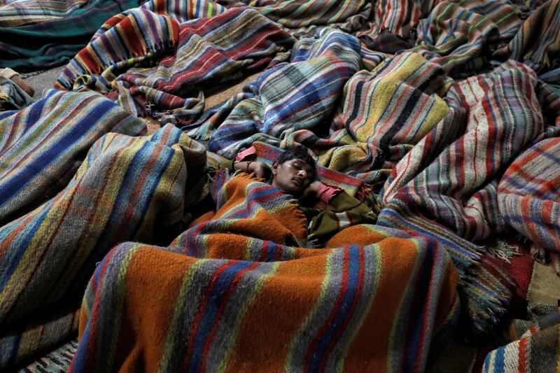 Homeless men sleep inside a government-run night shelter on a cold winter night in the old quarters of Delhi, India. Reuters