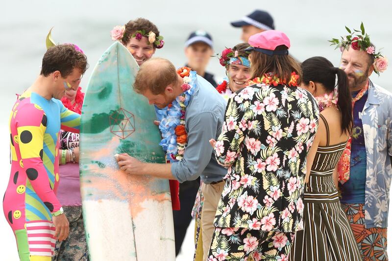 Prince Harry waxes a surfboard during a meet and greet on Bondi Beach with members of OneWave, a local surfing community group. Getty Images